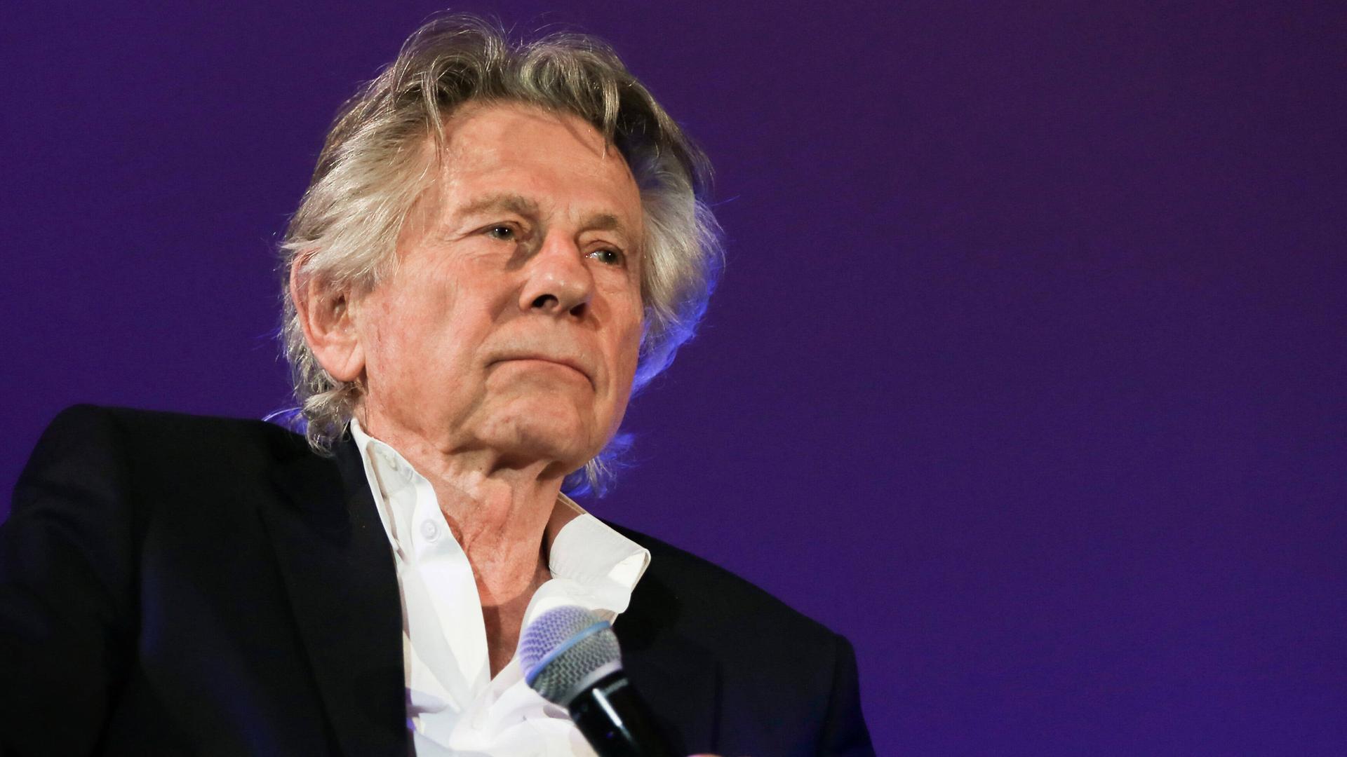 Der Regisseur Roman Polanski ist im Portrait zu sehen und hält ein Mikrofon in der linken Hand Der Regisseur Roman Polanski ist im Portrait zu sehen und hält ein Mikrofon in der linken Hand
