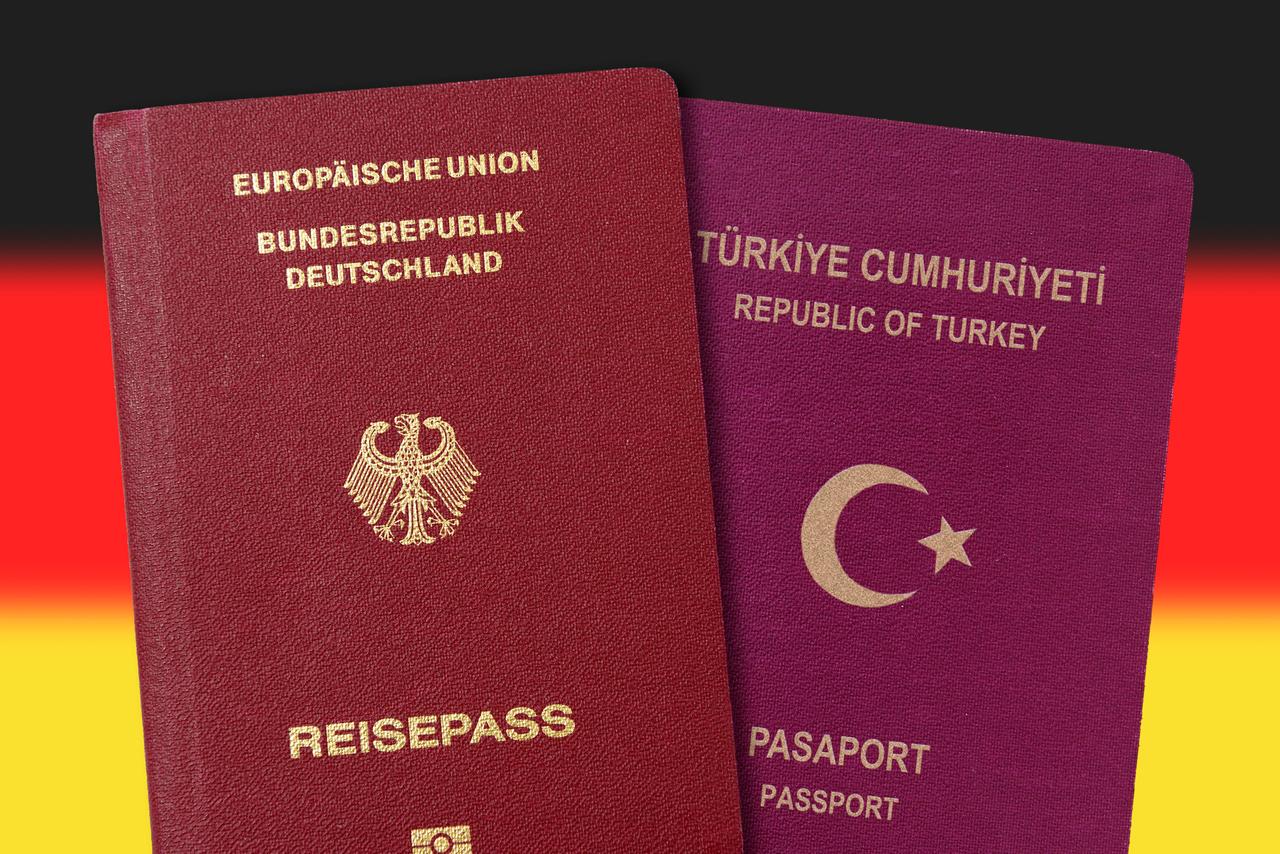 Deutscher und türkischer Pass vor einer Deutschlandfahne im Hintergrund 