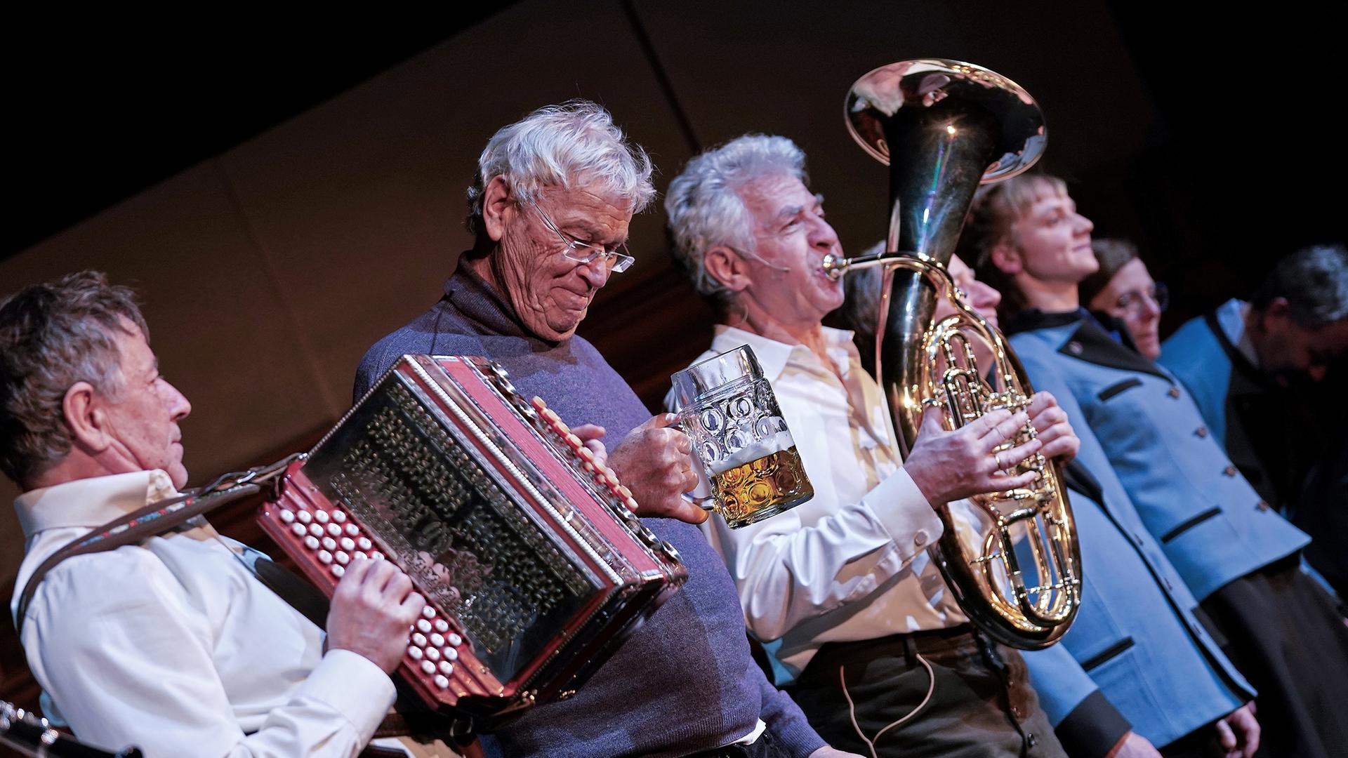 Gerhard Polt und die Well-Brüder musizierend auf der Bühne. 