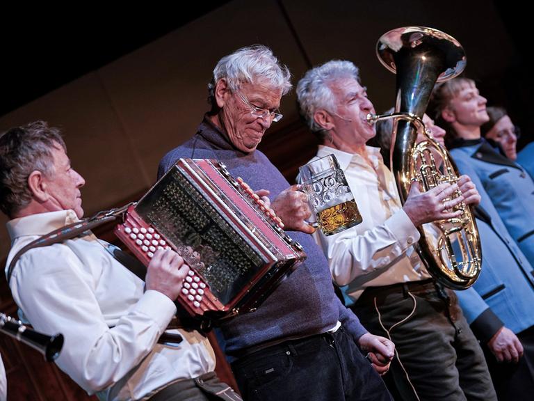 Gerhard Polt und die Well-Brüder musizierend auf der Bühne. Gerhard Polt und die Well-Brüder musizierend auf der Bühne.