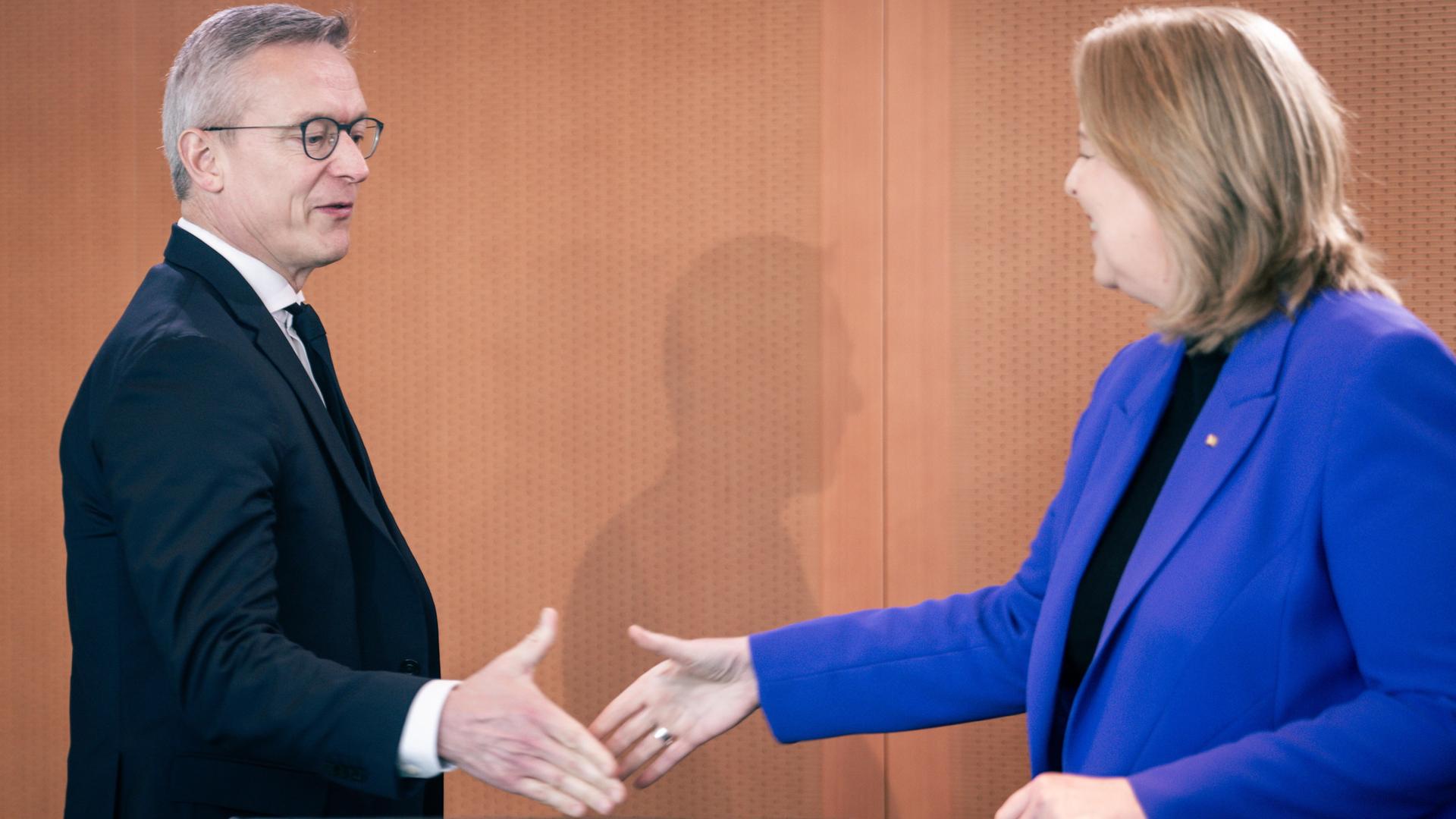 Bärbel Bas begrüßt Dr. Karsten Wildberger, sie wollen sich die Hände geben und lächeln. 