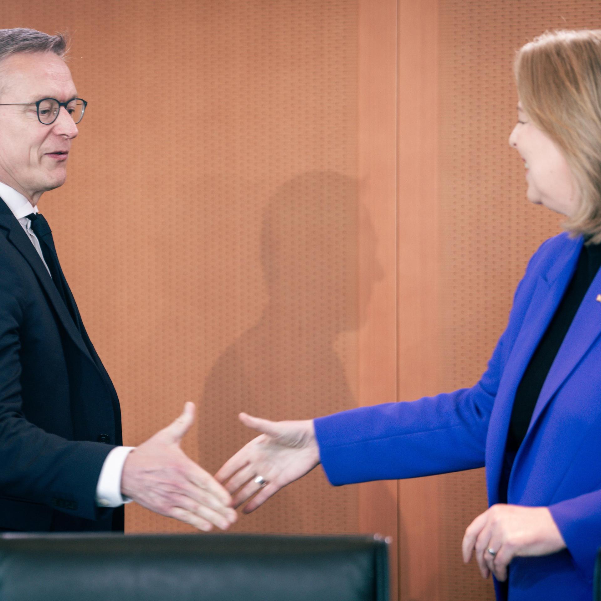 Bärbel Bas begrüßt Dr. Karsten Wildberger, sie wollen sich die Hände geben und lächeln. 