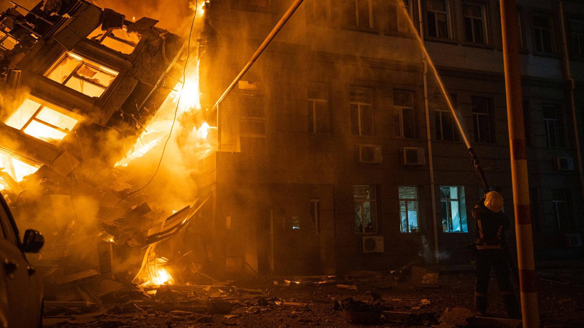 Ein Feuerwehrmann löscht nach einem russischen Raketenangriff den Brand an einem Verwaltungsgebäude im ukrainischen Odessa.