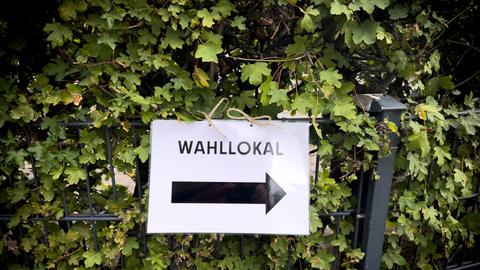 Ein Zettel weißt mit einem Pfeil nach rechts mit dem Hinweis "Wahllokal". 