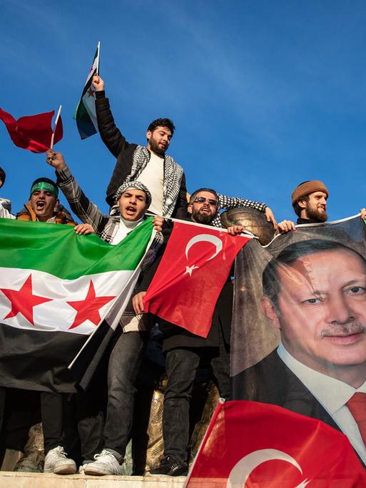 In der Türkei lebende Syrer feiern den Sturz des Assad-Regimes. Sie halten ein Foto des türkischen Präsidenten Erdogan und syrische Flaggen