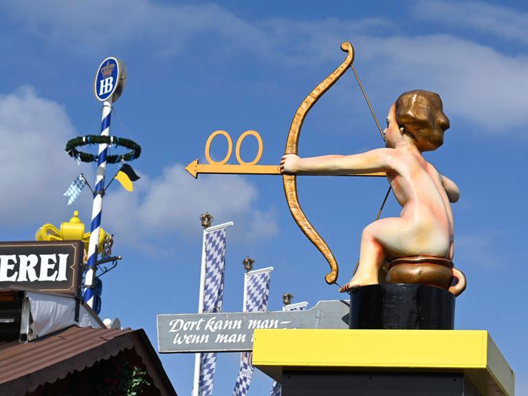 Wegweiser zu den Toiletten vom Oktoberfest 2022 auf der Theresienwiese zeigt einen Jungen auf einem Töpfchen mit Pfeil und Bogen.