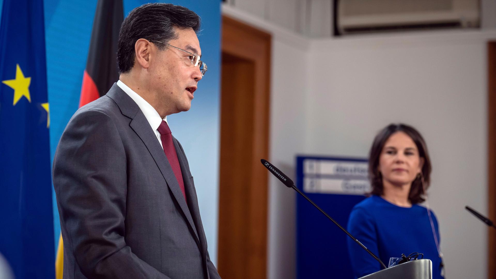 Bundesaußenministerin Baerbock und ihr chinesischer Amtskollege Qin GAng stehen jeweils hinter Rednerpulten mit Mikrofonen.