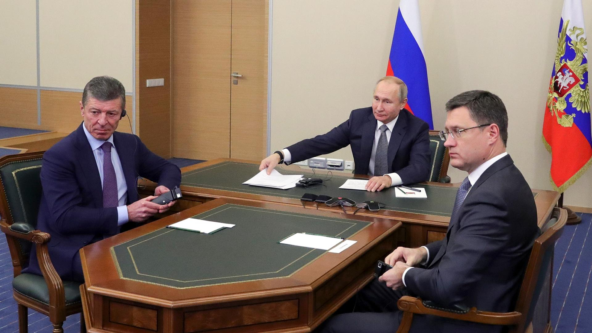 Wladimir Putin (M), Präsident von Russland, nimmt gemeinsam mit Dmitri Kosak (l), stellvertretender Premierminister von Russland, und Alexander Nowak, Energieminister von Russland, an einer Videokonferenz teil.