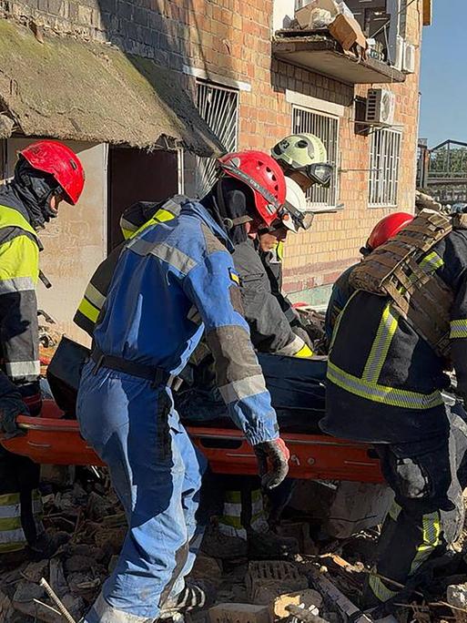 Rettungskräfte tragen am 28. August ein Opfer aus einem zerstörten Gebäude in Kiew