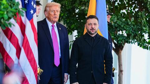 US-Präsident Trump begrüßt den ukrainischen Staatschef Selenskyj bei einem Besuch im Weißen Haus in Washington. Im Bildhintergrund sind die Flaggen ihrer Heimatländer zu sehen.