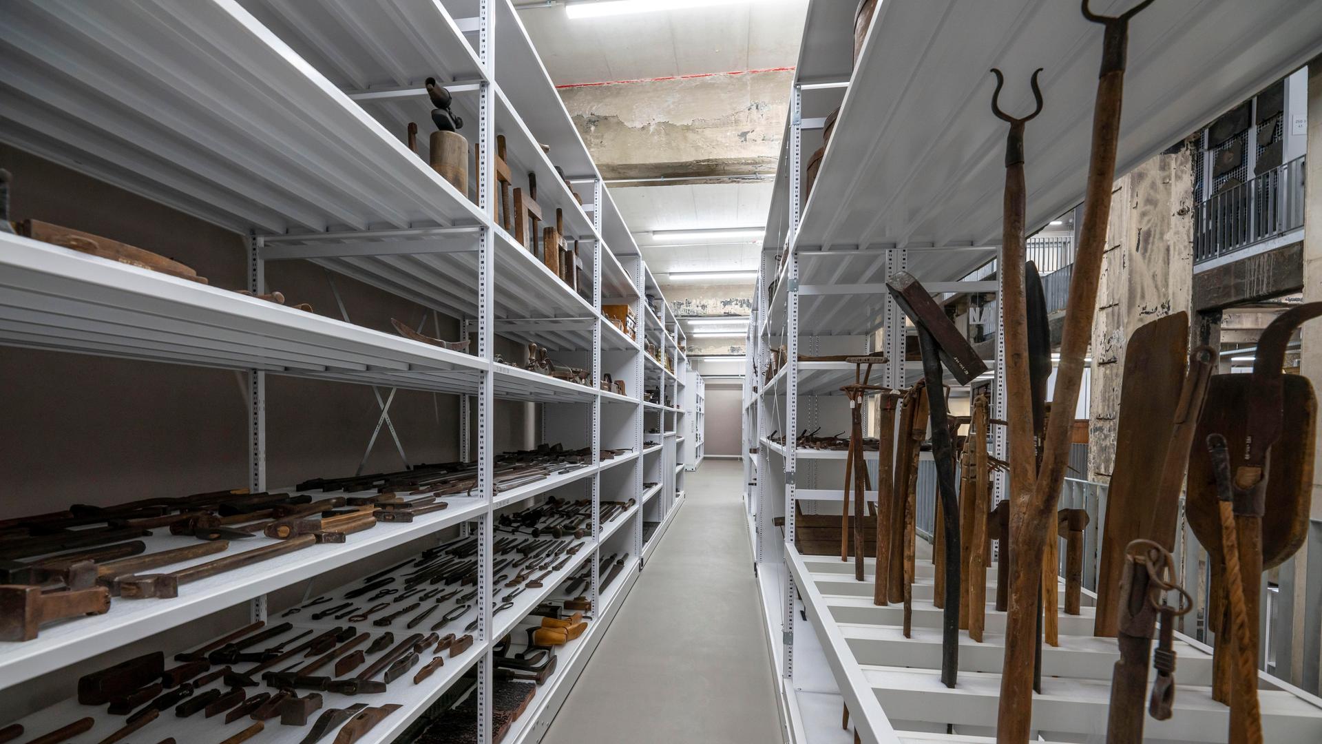 Das Schaudepot des Ruhr Museums auf der Kokerei Zollverein in Essen. Auf 3 Etagen werden die mehr als 25.000 Exponate des Museums gezeigt, die sonst in Lagerhäusern archiviert waren. Man sieht Regale voller alter Geräte wie Schaufeln und Hämmer.