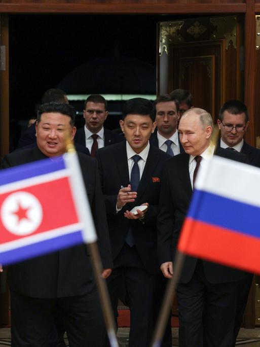 Wladimir Putin trifft Kim Jong Un in Nordkorea, die Flaggen beider Staaaten sind zu sehen.