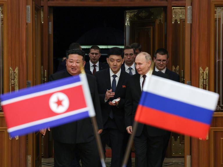 Wladimir Putin trifft Kim Jong Un in Nordkorea, die Flaggen beider Staaaten sind zu sehen.