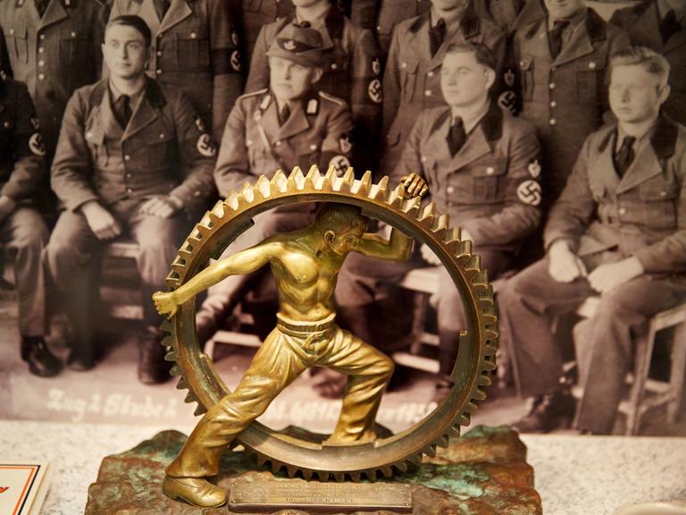 Ein Arbeiter in einem mannshohen Zahnrad: Eine Skulptur der Deutschen Arbeitsfront als Geschenk an Robert Ley, 1938. (Foto: Deutsches Historisches Museum, Berlin)