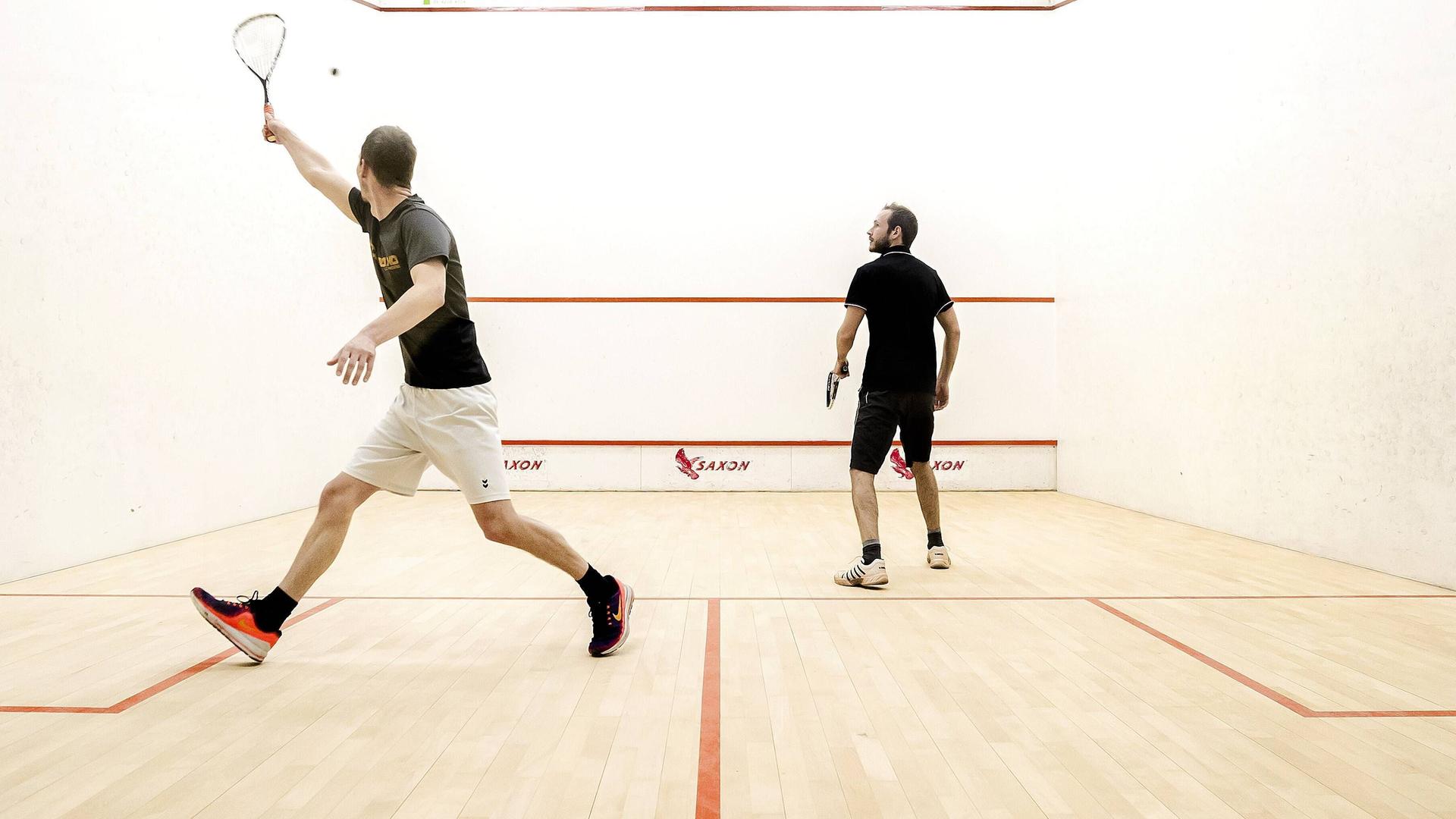 Zwei Squash-Spieler in einer Halle Zwei Squash-Spieler in einer Halle