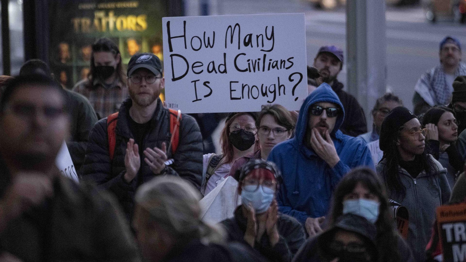 Menschen protestieren in Minneapolis gegen die Einsätze der ICE-Behörde und halten Transparente hoch. 
