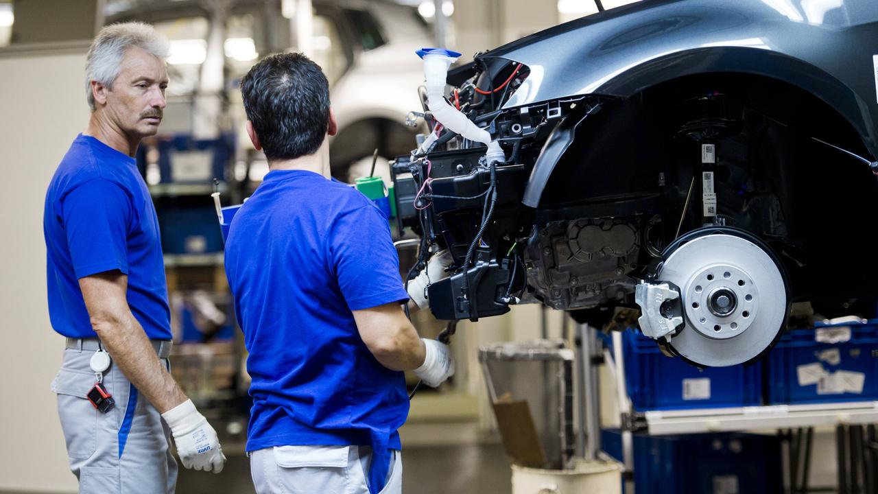 Monteure am Fließband in der Fertigung im Werk der VW AG Wolfsburg.