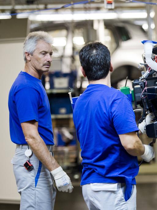 Monteure am Fließband in der Fertigung im Werk der VW AG Wolfsburg.