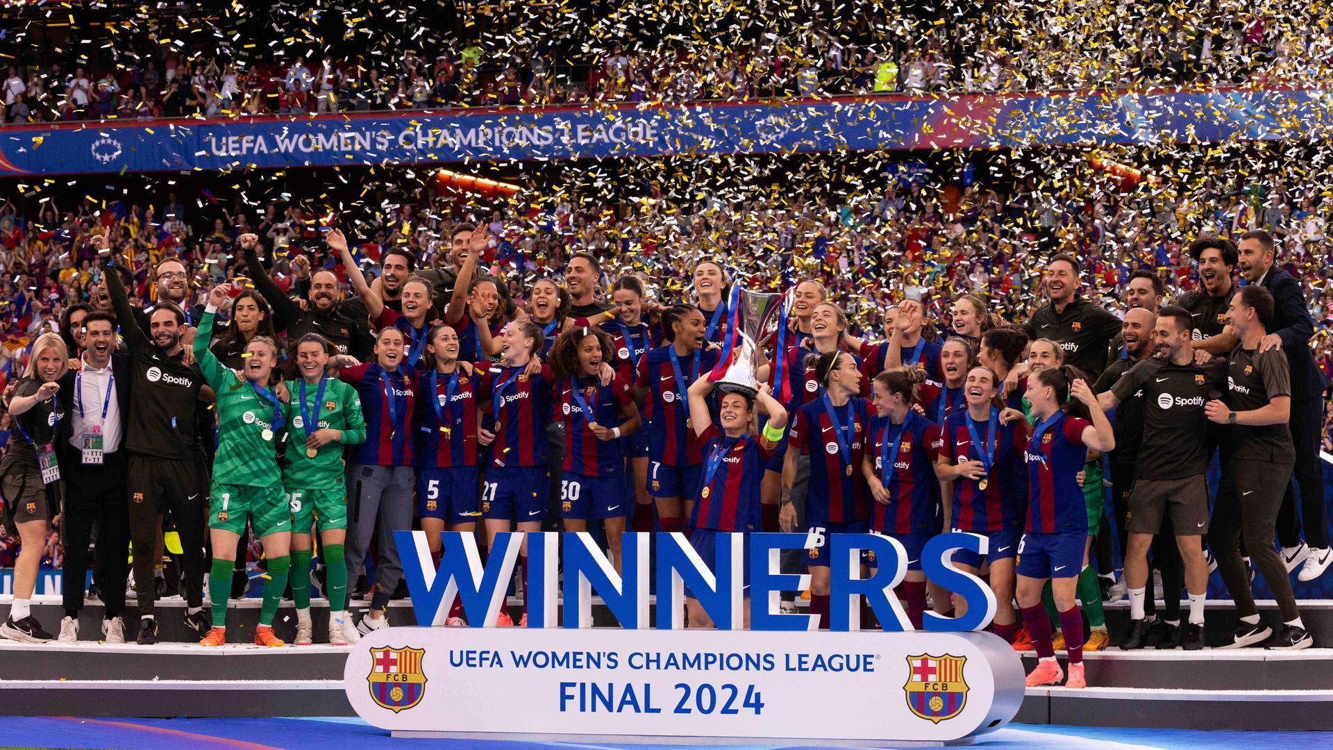 Die Spielerinnen des FC Barcelona feiern den Gewinn der Women's Champions League auf dem Rasen.