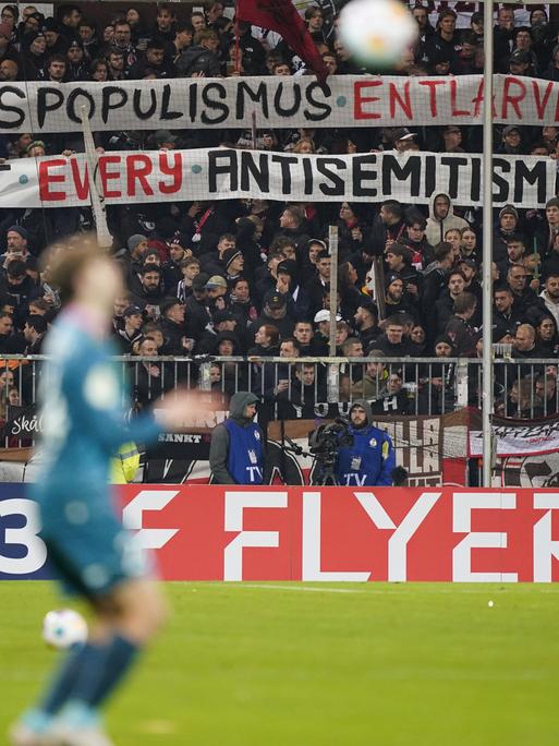 Beim Bundesliga-Spiel FC St. Pauli gegen den FC Schalke halten St.-Pauli-Fans ein Banner hoch mit der Aufschrift "Rechtspopulismus entlarven - against every antisemitism."