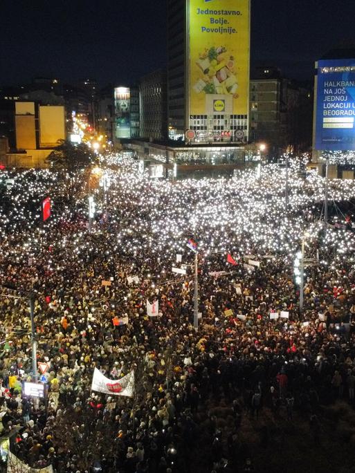 Ein Meer an Menschen überflutet den Slavija Platz in Belgrad in Belgrad. Die dunklen Straßen der serbischen Hauptstadt sind mit unzähligen Lichtern beleuchtet. 