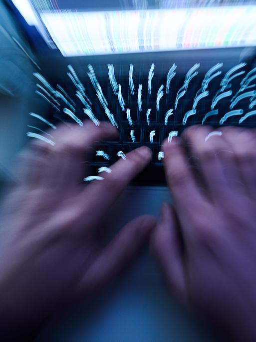 Hände tippen auf einer Computer-Tastatur.