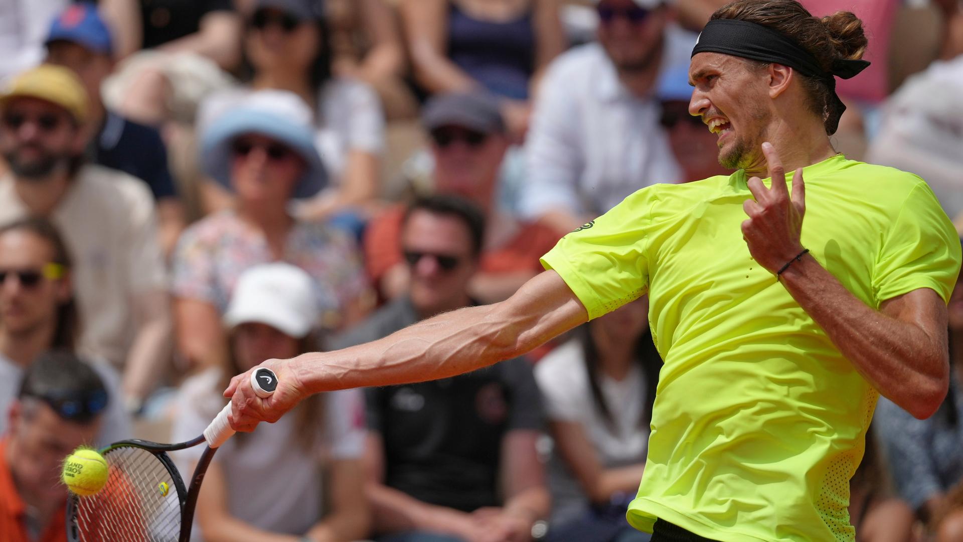 Alexander Zverev im neongelben Shirt ist von der Seite zu sehen. Er schlägt gegen den Ball. Alexander Zverev im neongelben Shirt ist von der Seite zu sehen. Er schlägt gegen den Ball.