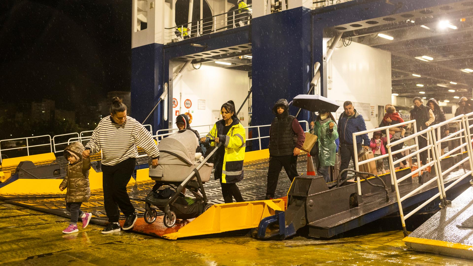  Menschen steigen im Hafen von Piräus in der Nähe von Athen von einer Fähre, mit der sie die griechische Insel Santorini verlassen haben.