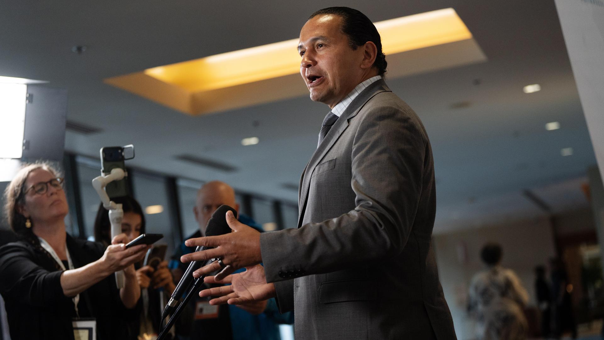 Der Premierminister der kanadischen Provinz Manitoba, Wab Kinew, steht vor Journalisten und gestikuliert mit beiden Händen.