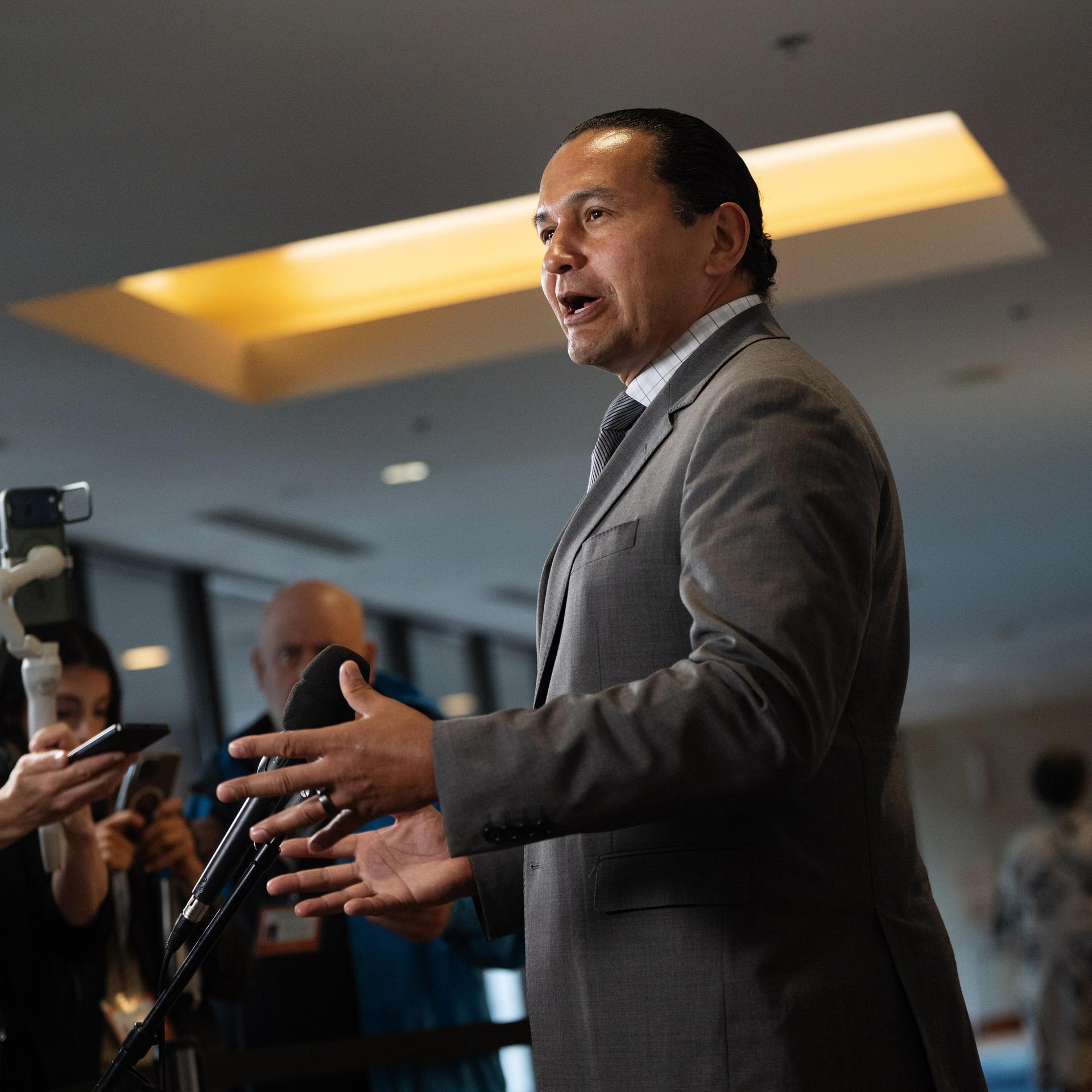 Der Premierminister der kanadischen Provinz Manitoba, Wab Kinew, steht vor Journalisten und gestikuliert mit beiden Händen.