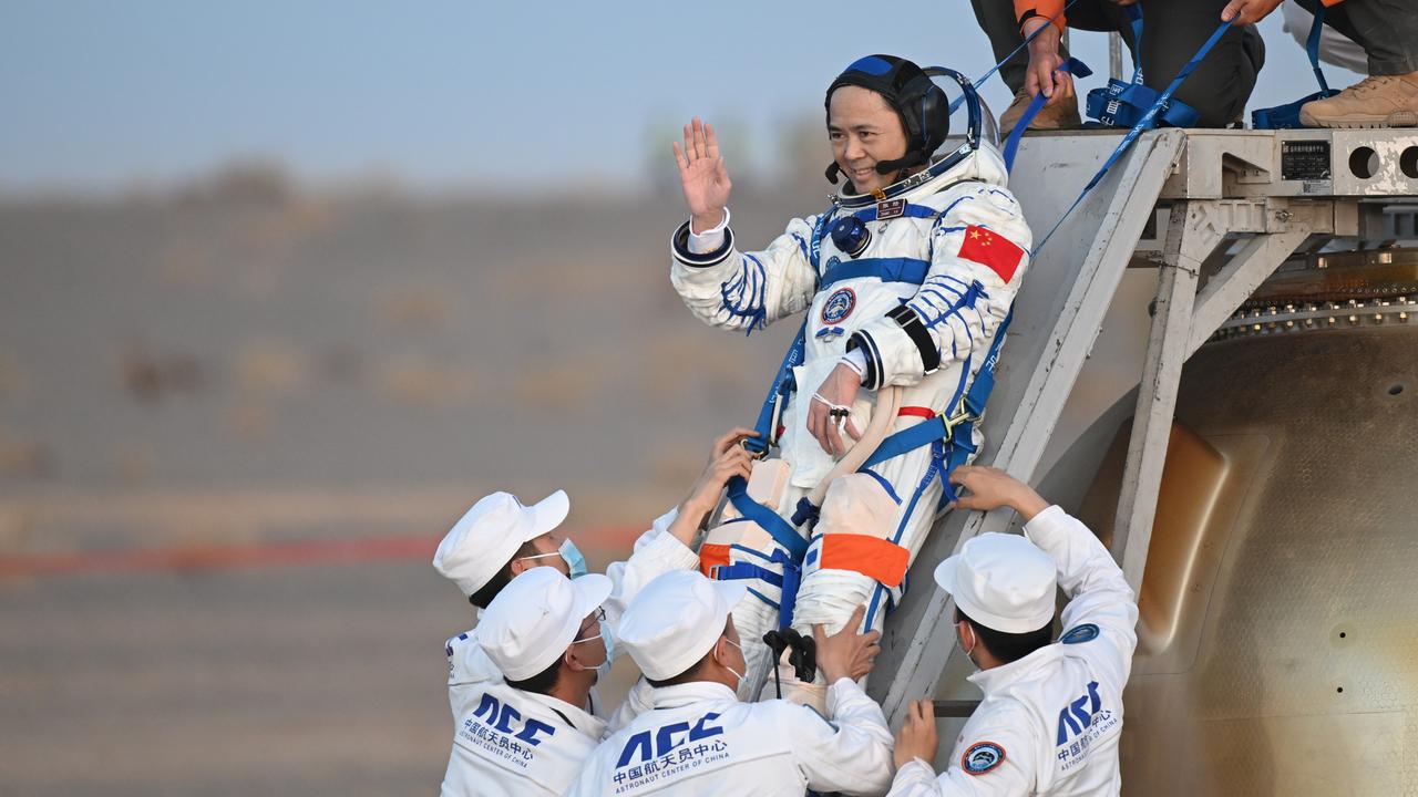 Mehrere Menschen helfen einem Astronauten beim Ausstieg aus der Landekapsel. 