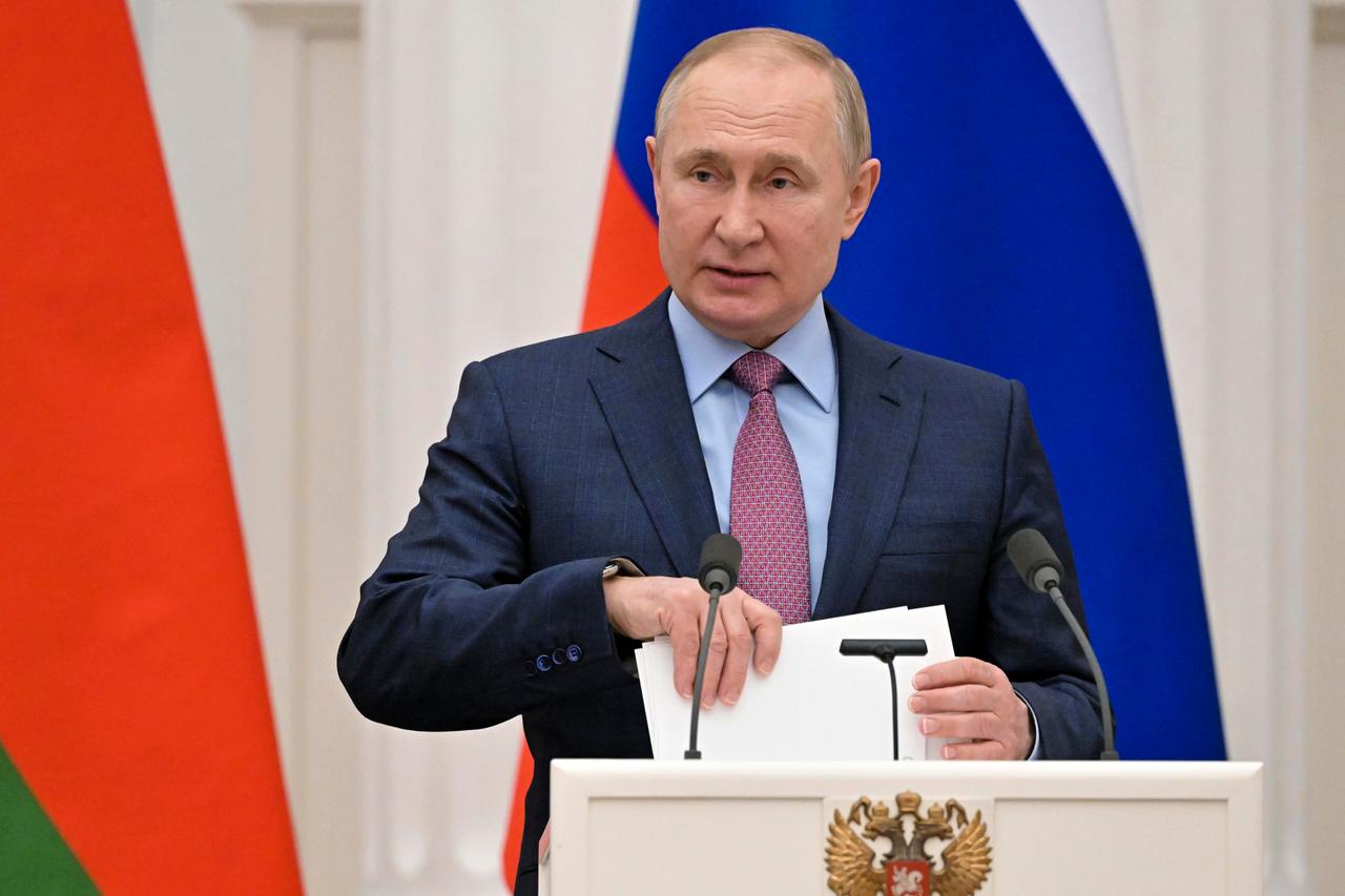 Der russische Präsident Wladimir Putin mit Unterlagen in der Hand vor einem Mikrofon im Kreml in Moskau.