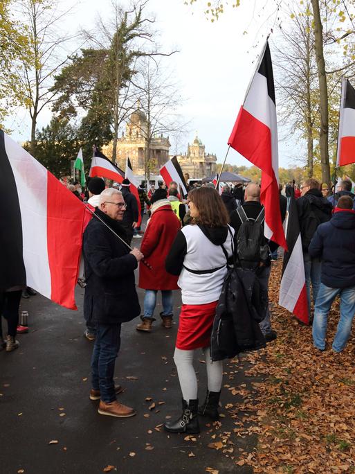 Teilnehmer mit schwarz-weiß-roten Reichsflaggen während einer Demonstration von Reichsbürgern und anderen Rechtsextremen für die Wiedereinführung der Monarchie am Neuen Palais in Potsdam. 