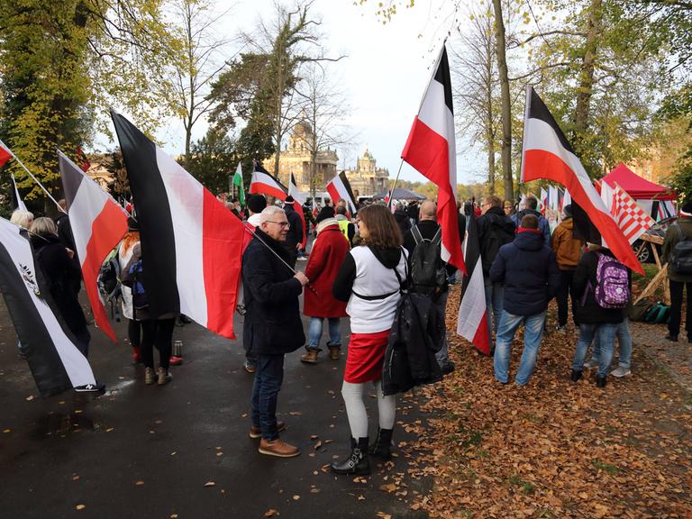 Teilnehmer mit schwarz-weiß-roten Reichsflaggen während einer Demonstration von Reichsbürgern und anderen Rechtsextremen für die Wiedereinführung der Monarchie am Neuen Palais in Potsdam. 