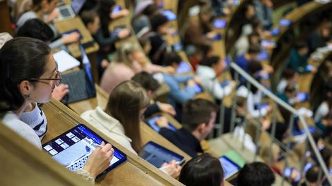 Medizinstudenten sitzen im Hörsaal Anatomie in einer Vorlesung. Im Vordergrund eine junge Frau mit I-Pad. 
