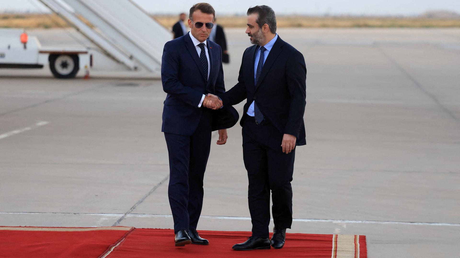 Der französische Präsident Emmanuel Macron (links) wird bei seiner Ankunft zu einem Staatsbesuch am internationalen Flughafen von Damaskus von dem syrischen Außenminister Asaad al-Shaibani (rechts) begrüßt. 