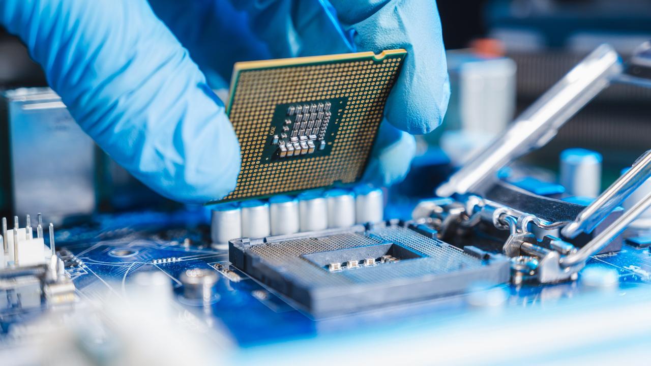 Halbleiter-Produktion: Nahaufnahme einer Hand, die eine CPU (Central processing unit) einsetzt.