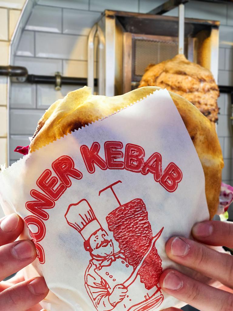Ein Frisch zubereiteter Döner Kebab in der Hand eines Kunden
