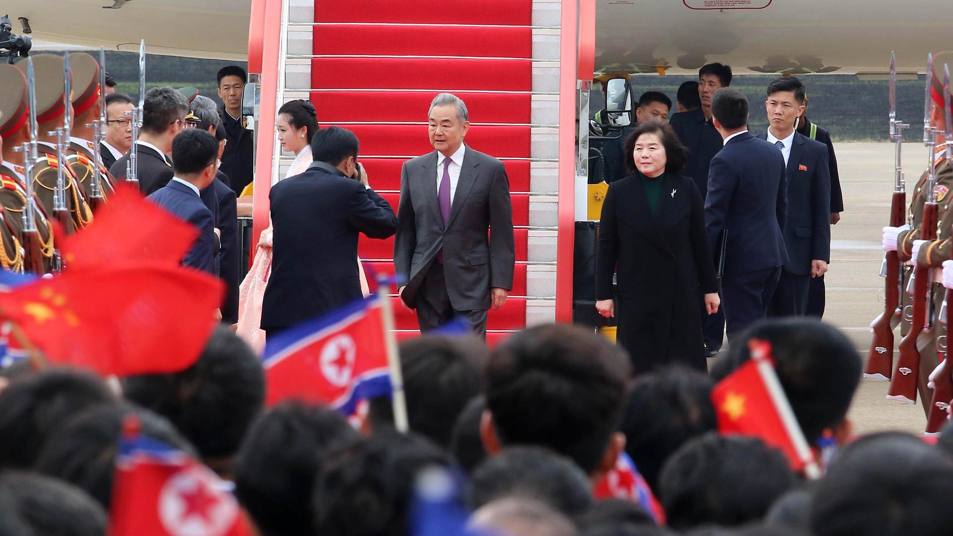 Der chinesische Außenminister Wang wird in Pjöngjang am Flughafen von vielen Menschen und mit militärischen Ehren empfangen.