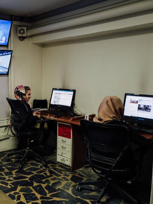 Zwei afghanische Journalistinnen von Tolo News arbeiten im Büro.