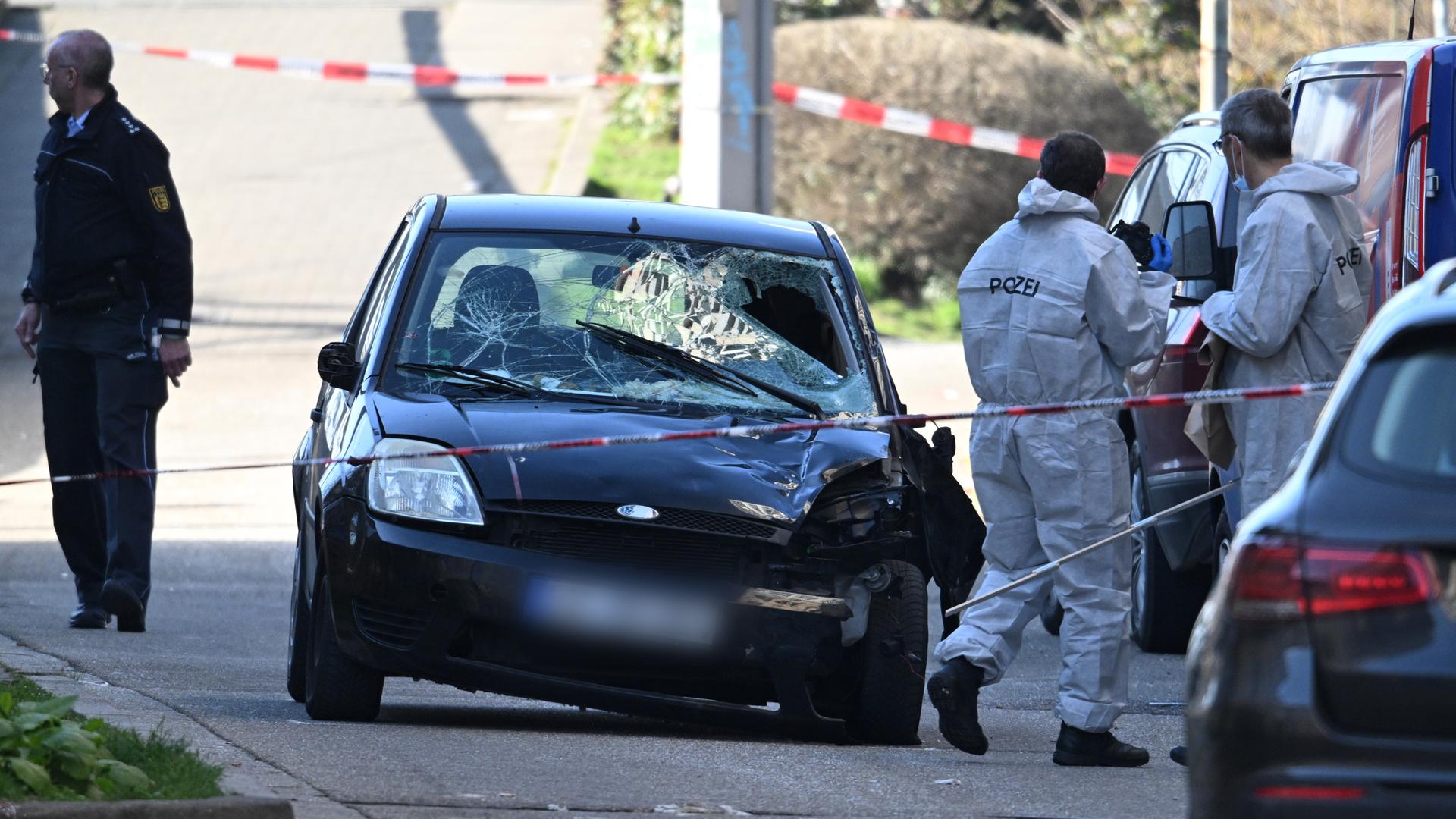 Polizisten untersuchen das Auto von dem Täter.