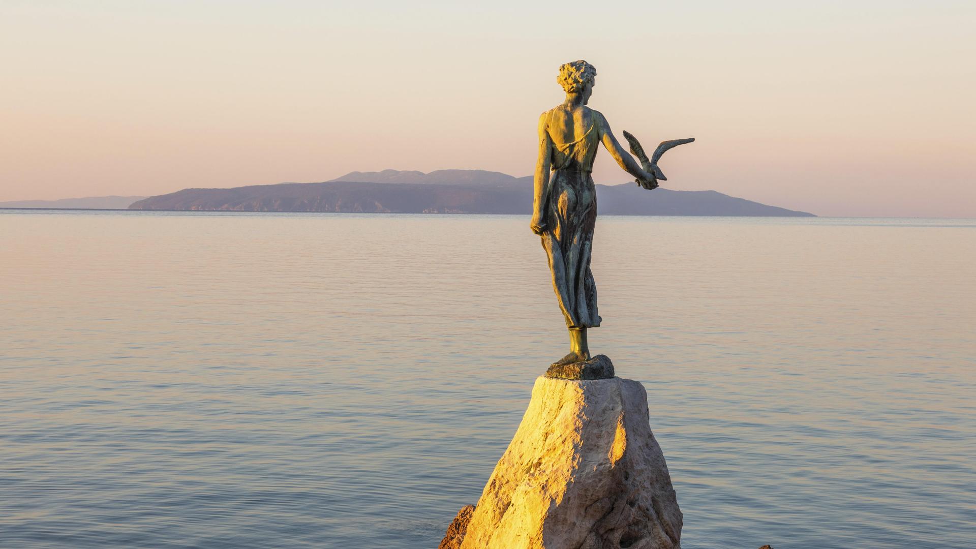 Die Statue "Mädchen mit Möwe im Morgenlicht" ist bei Sonnenaufgang bei Opatija in Kroatien zu sehen. Die Statue "Mädchen mit Möwe im Morgenlicht" ist bei Sonnenaufgang bei Opatija in Kroatien zu sehen.