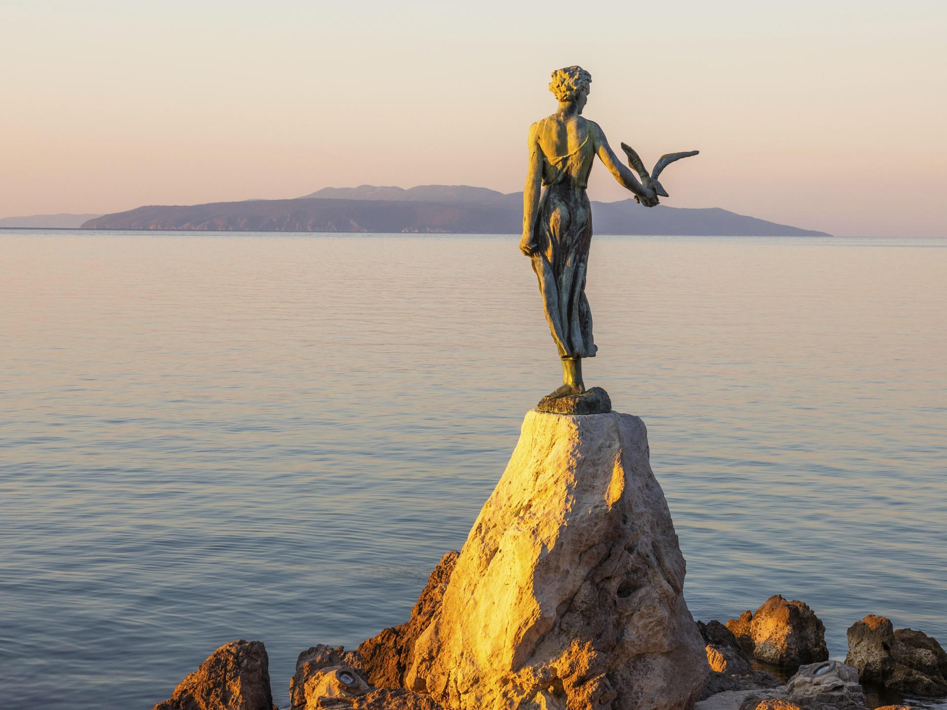 Die Statue "Mädchen mit Möwe im Morgenlicht" ist bei Sonnenaufgang bei Opatija in Kroatien zu sehen. Die Statue "Mädchen mit Möwe im Morgenlicht" ist bei Sonnenaufgang bei Opatija in Kroatien zu sehen.