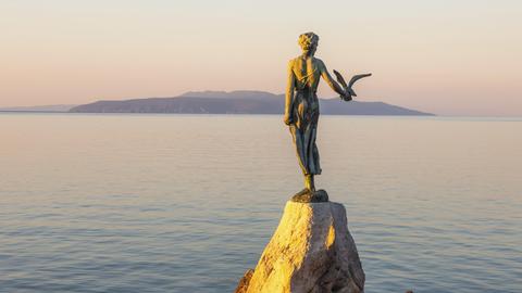 Die Statue "Mädchen mit Möwe im Morgenlicht" ist bei Sonnenaufgang bei Opatija in Kroatien zu sehen. 