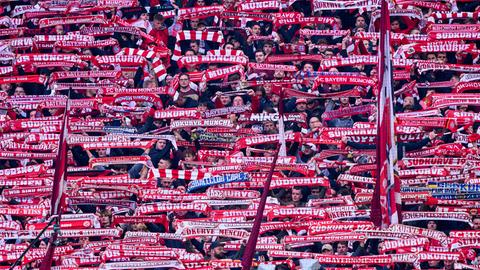 In der Südkurve des Münchner Stadions halten Bayern-Fans rote Schals nach oben.