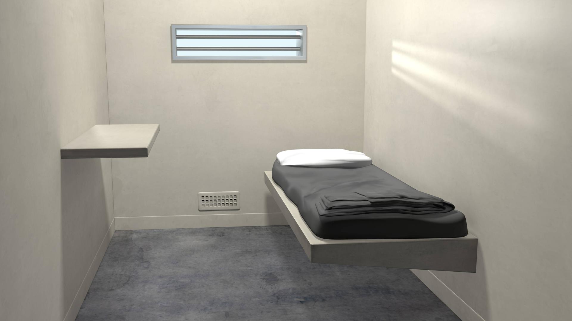 In einer Gefängniszelle steht ein Bett. In einer Gefängniszelle steht ein Bett.