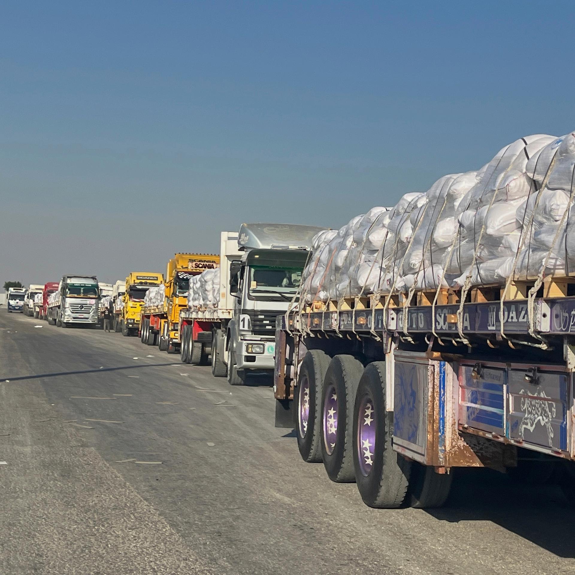 Das Foto zeigt Lastwagen mit humanitären Hilfsgütern am Grenzübergang Rafah zwischen Ägypten und dem Gazastreifen.