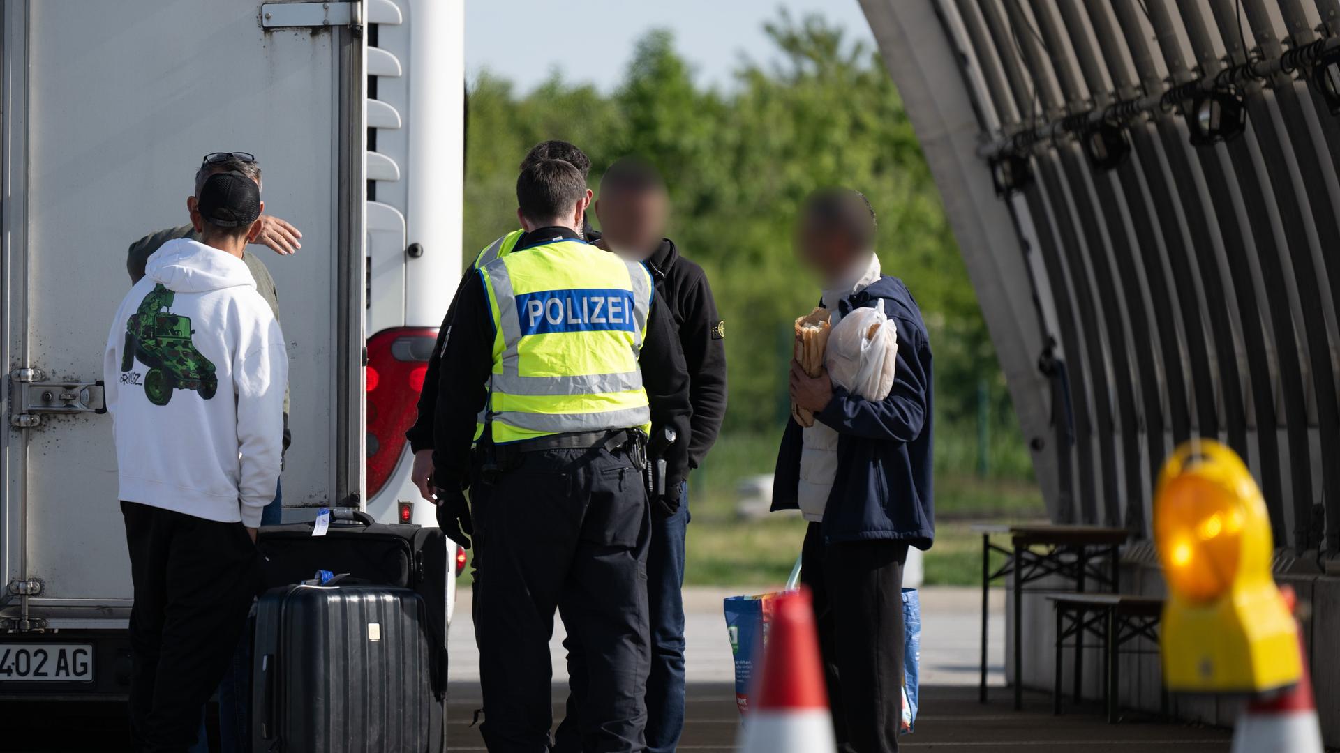 Bundespolizisten stehen anlässlich von Grenzkontrollen am Bundespolizeirevier Breitenau an der Autobahn 17 nahe der deutsch-tschechischen Grenze vor einer Personengruppe aus einem Reisebus. Bundespolizisten stehen anlässlich von Grenzkontrollen am Bundespolizeirevier Breitenau an der Autobahn 17 nahe der deutsch-tschechischen Grenze vor einer Personengruppe aus einem Reisebus.