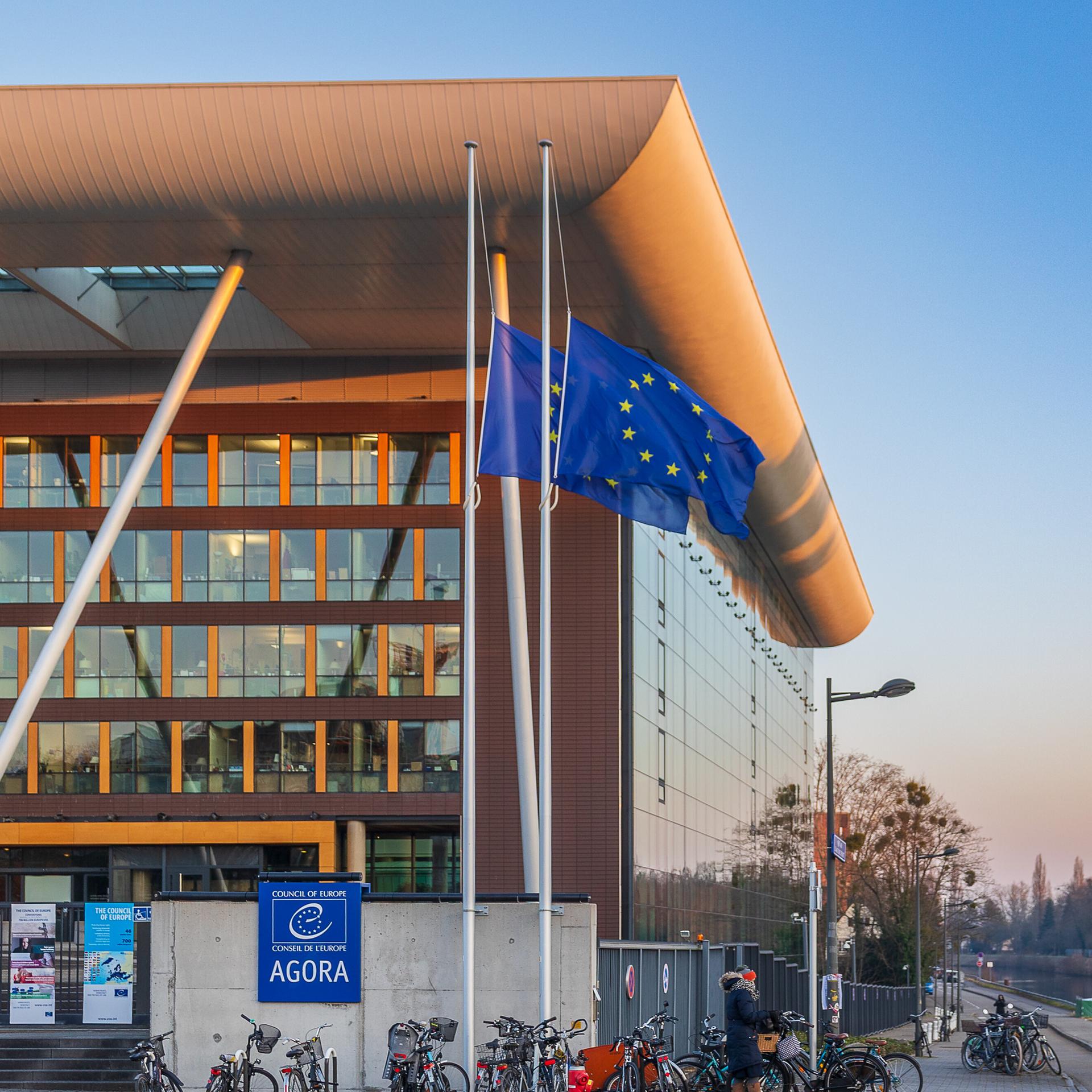Das Agora-Gebäude des Europarats in Straßburg mit zwei Europafahnen. 