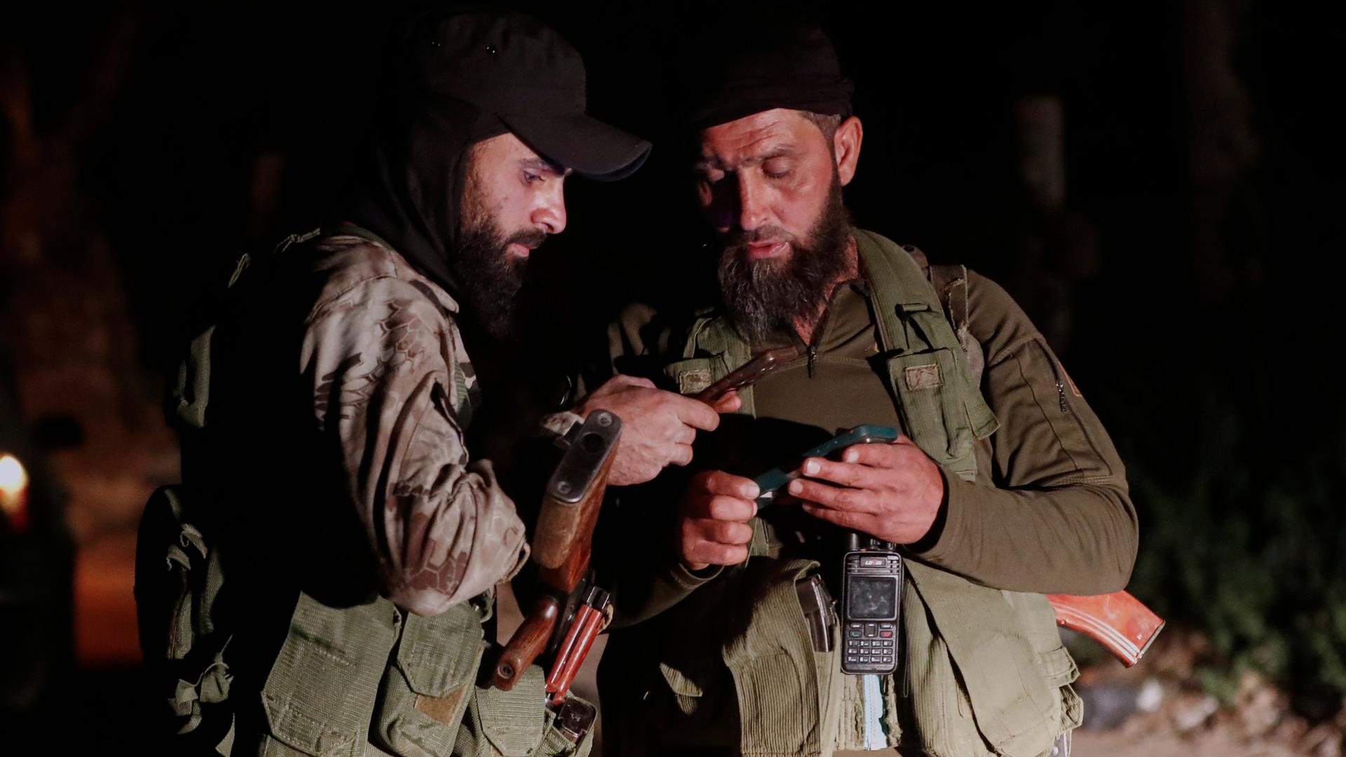 Syrische Sicherheitskräfte überprüfen ihre Mobiltelefone.
      
